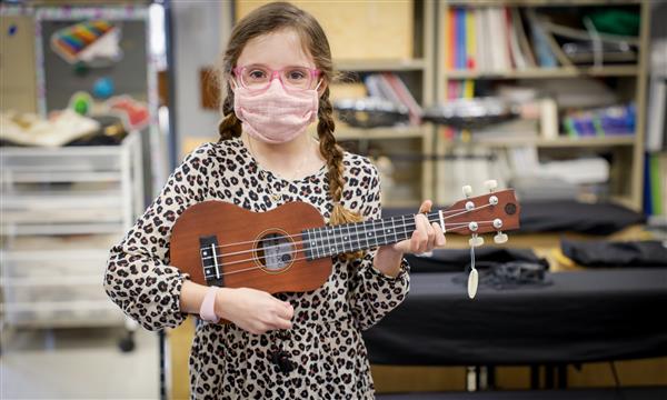 girl plays ukulele
